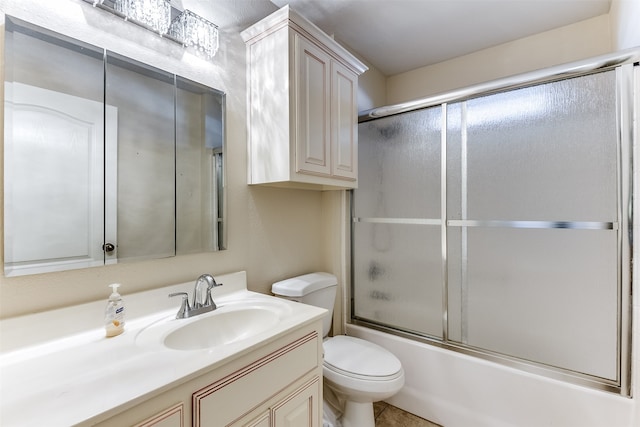 full bathroom featuring tile patterned flooring, vanity, bath / shower combo with glass door, and toilet