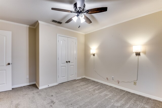 unfurnished bedroom featuring ceiling fan, a closet, light carpet, and ornamental molding