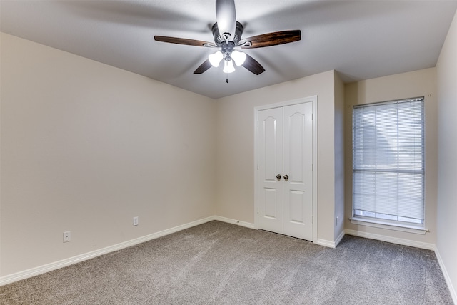 unfurnished bedroom with ceiling fan, a closet, and carpet