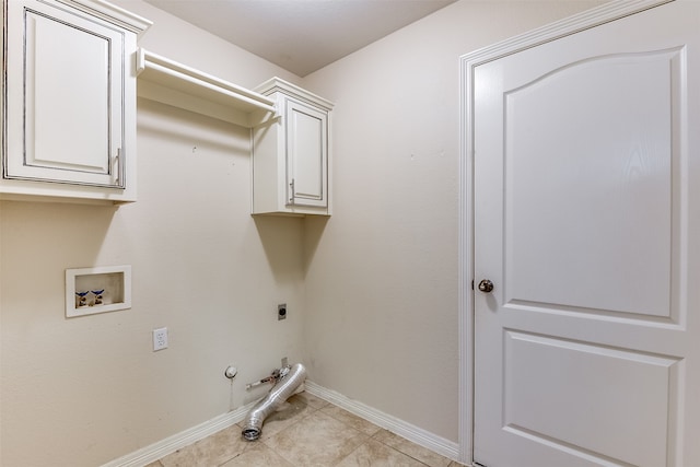 laundry area featuring washer hookup, light tile patterned floors, hookup for an electric dryer, gas dryer hookup, and cabinets