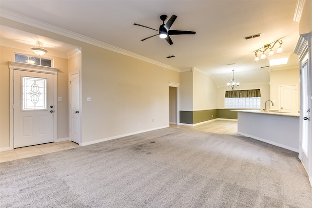 unfurnished living room with light carpet, ceiling fan with notable chandelier, and crown molding