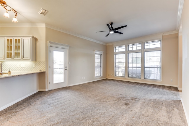 unfurnished living room with ceiling fan, ornamental molding, and light carpet