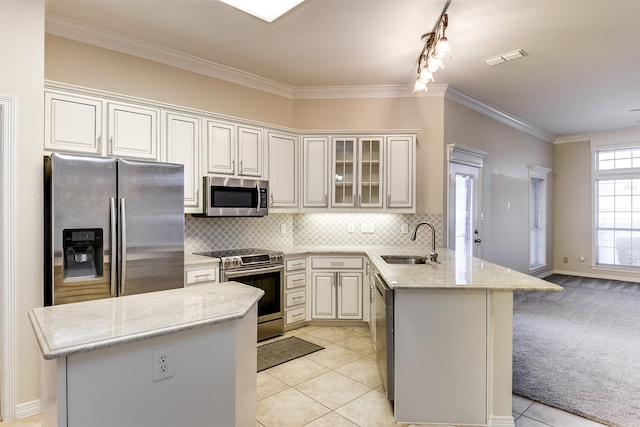 kitchen featuring sink, light stone counters, kitchen peninsula, appliances with stainless steel finishes, and light tile patterned floors