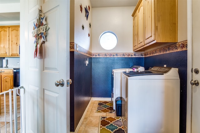 clothes washing area featuring light tile patterned floors, cabinets, and washing machine and clothes dryer