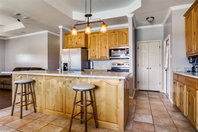 kitchen with crown molding, stainless steel appliances, a raised ceiling, and a kitchen bar