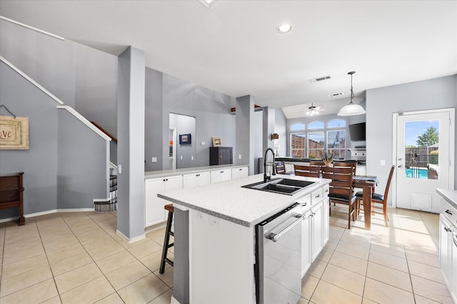 kitchen featuring white cabinets, hanging light fixtures, sink, stainless steel dishwasher, and a center island with sink