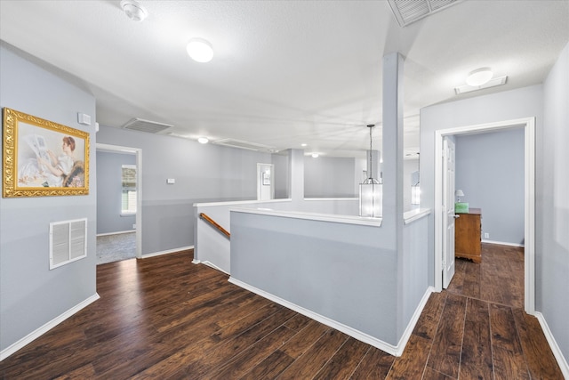 hall with dark hardwood / wood-style floors and an inviting chandelier