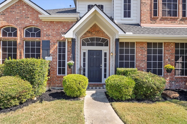 view of exterior entry featuring a lawn