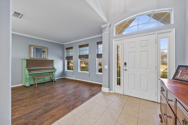 entrance foyer with ornamental molding and light wood-type flooring