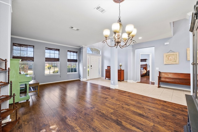 living room featuring a notable chandelier, light wood-type flooring, and crown molding