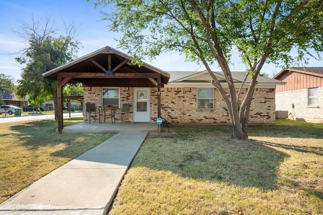 view of front of property featuring a patio and a front yard