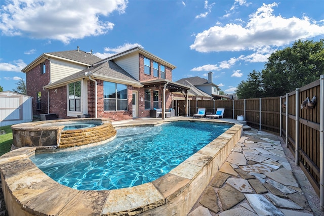 view of pool with a shed, an in ground hot tub, and a patio