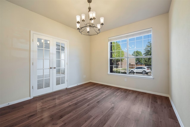 spare room featuring french doors, a notable chandelier, and dark hardwood / wood-style flooring