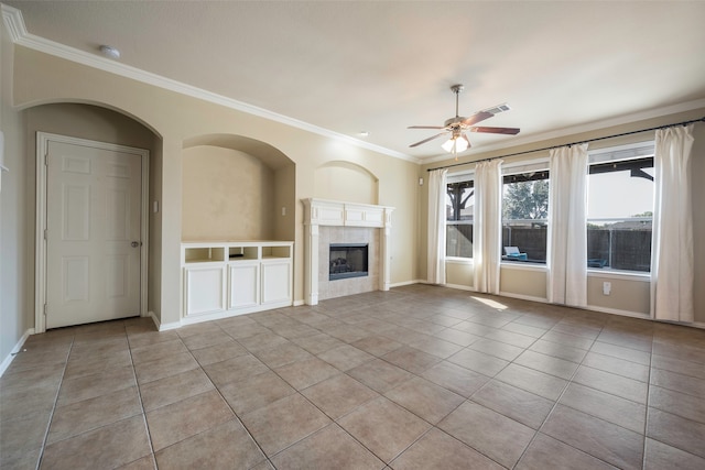 unfurnished living room with ornamental molding, light tile patterned floors, a tile fireplace, and ceiling fan