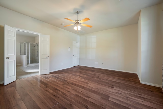 unfurnished bedroom featuring ceiling fan, dark hardwood / wood-style flooring, and ensuite bath