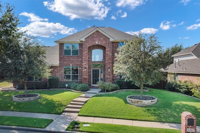 1310 Gold Coast Dr, Rockwall, TX 75087 - traditional home with roof with shingles, brick siding, and a front lawn