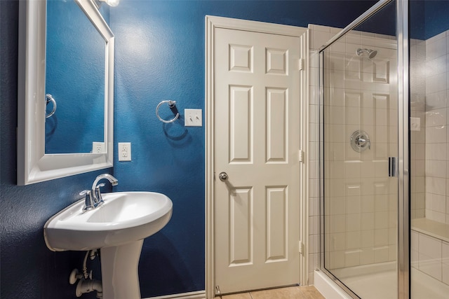 bathroom featuring a shower with shower door and tile patterned flooring