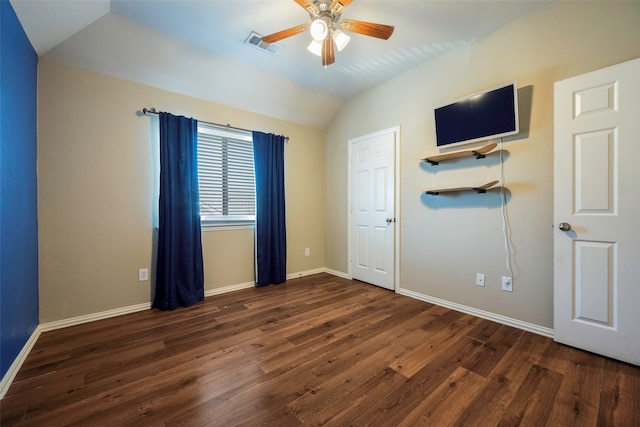 empty room featuring lofted ceiling, dark wood-type flooring, and ceiling fan