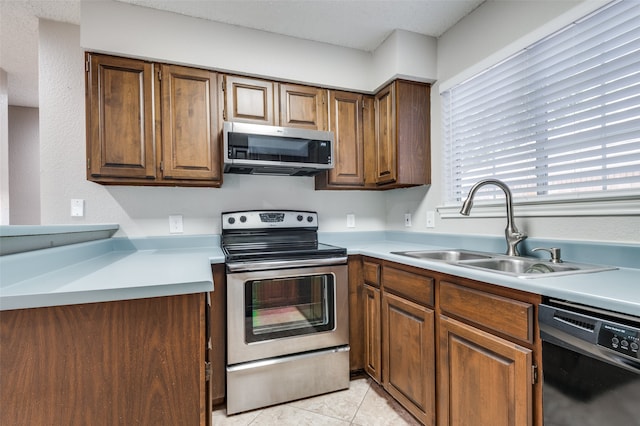 kitchen featuring sink, light tile patterned floors, and stainless steel appliances