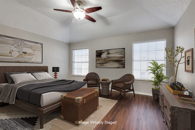 bedroom featuring multiple windows, a textured ceiling, dark hardwood / wood-style flooring, and ceiling fan