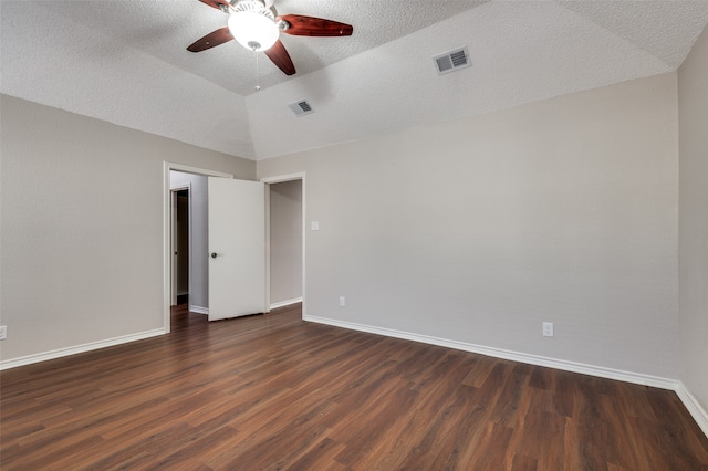 empty room with a textured ceiling, dark wood-type flooring, ceiling fan, and lofted ceiling