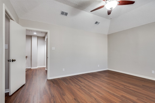 empty room featuring dark hardwood / wood-style floors, ceiling fan, lofted ceiling, and a textured ceiling