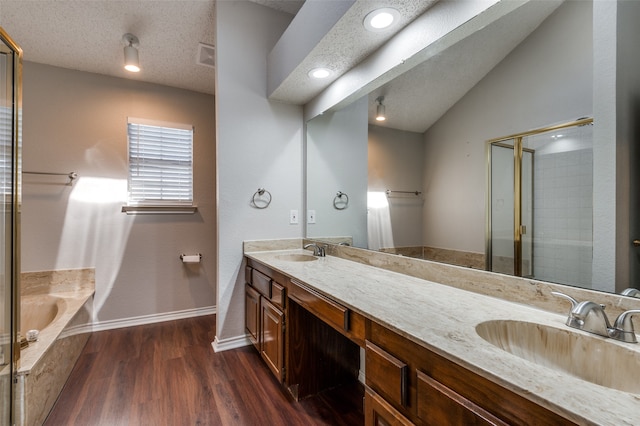 bathroom featuring vanity, lofted ceiling, hardwood / wood-style flooring, shower with separate bathtub, and a textured ceiling