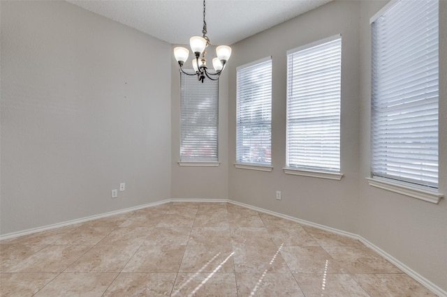 empty room featuring light tile patterned floors and a chandelier