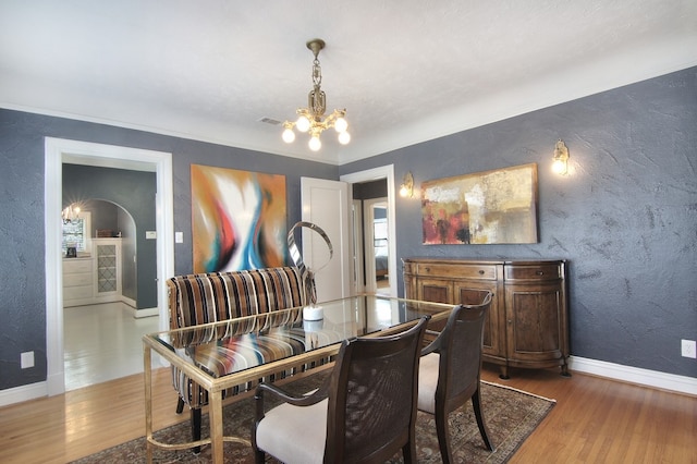 dining space with hardwood / wood-style flooring and a notable chandelier