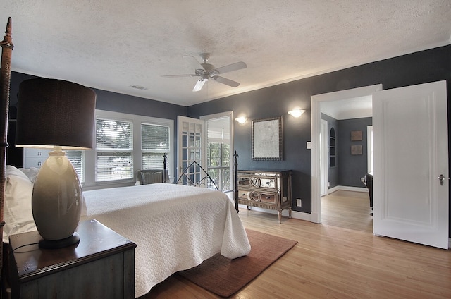 bedroom featuring ceiling fan, a textured ceiling, and light hardwood / wood-style flooring