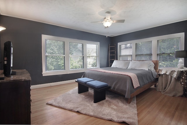 bedroom featuring ceiling fan, a textured ceiling, and light hardwood / wood-style floors