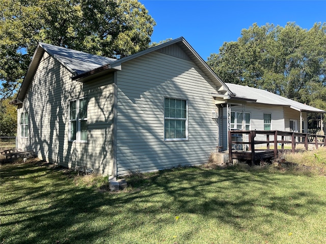 back of house with a wooden deck and a lawn