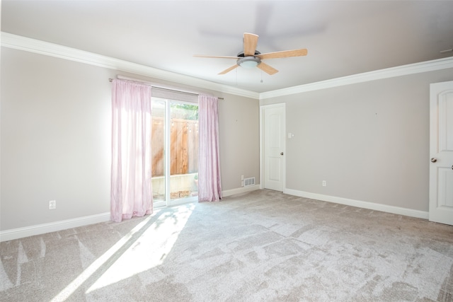 empty room featuring crown molding, light colored carpet, and ceiling fan