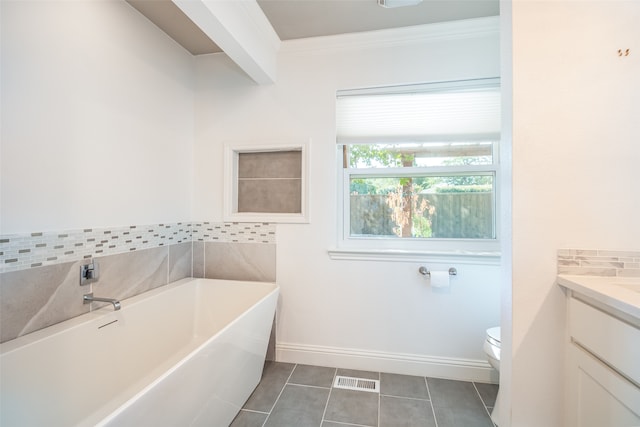 bathroom featuring a tub, vanity, tile patterned flooring, ornamental molding, and toilet