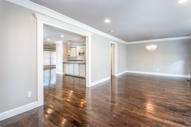 unfurnished room with crown molding, an inviting chandelier, and dark hardwood / wood-style flooring