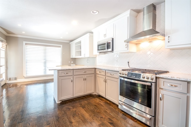 kitchen with white cabinets, wall chimney exhaust hood, dark wood-type flooring, appliances with stainless steel finishes, and light stone countertops