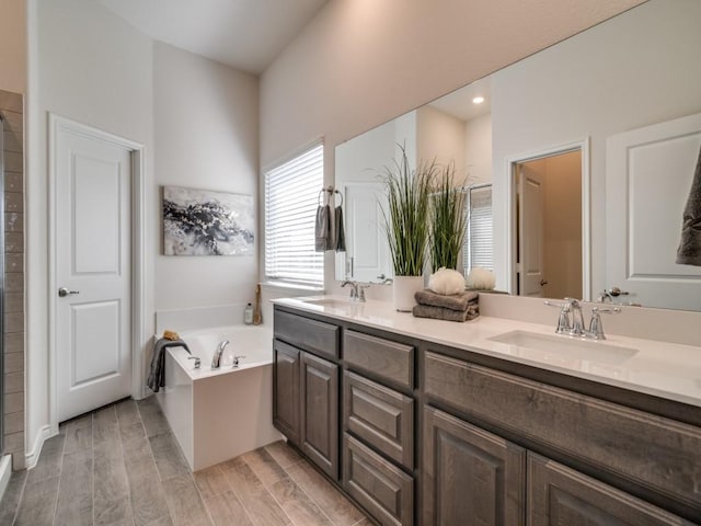 full bath featuring double vanity, a garden tub, walk in shower, and a sink