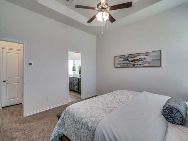 carpeted bedroom with ensuite bath and ceiling fan