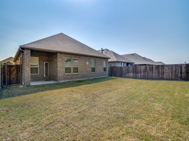 back of property with a patio area and a yard