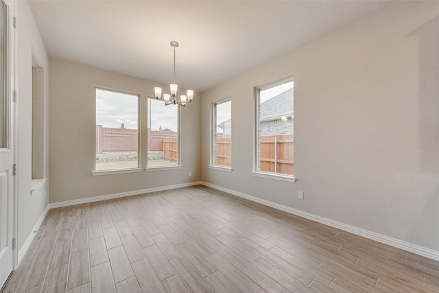 unfurnished dining area featuring a chandelier and a wealth of natural light