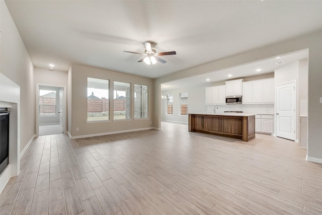 unfurnished living room with ceiling fan and sink