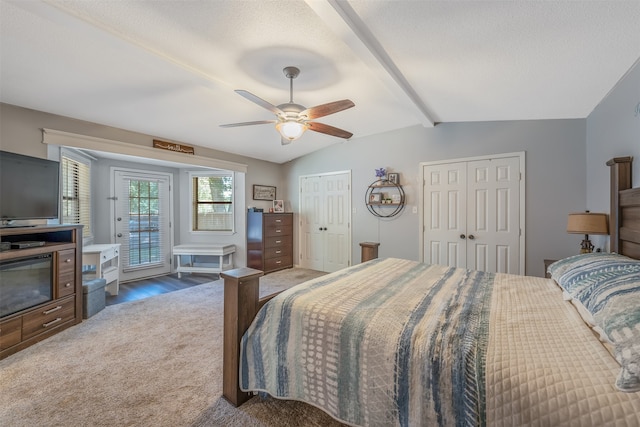 carpeted bedroom with ceiling fan, vaulted ceiling with beams, a textured ceiling, and multiple closets