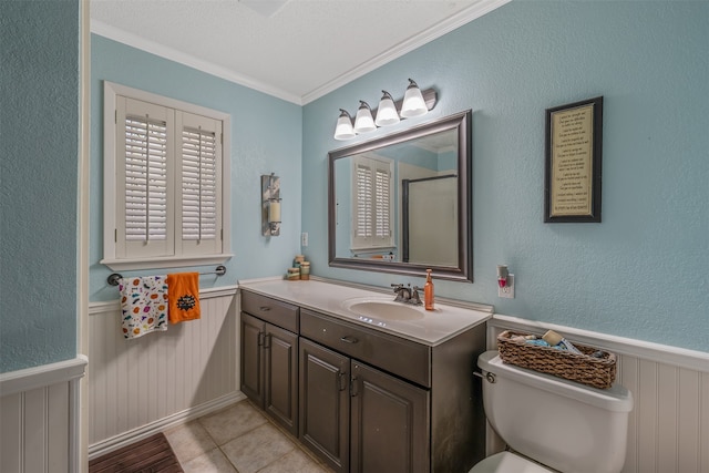 bathroom with tile patterned flooring, crown molding, vanity, and toilet