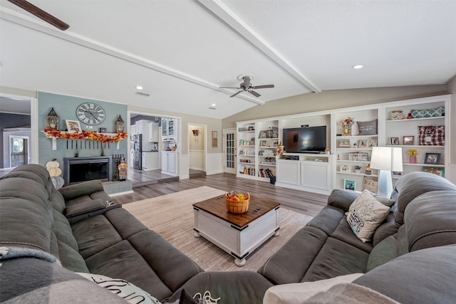 living room featuring ceiling fan, vaulted ceiling with beams, a textured ceiling, and hardwood / wood-style floors