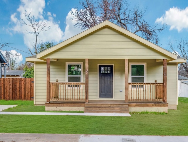 bungalow-style home featuring covered porch and a front lawn