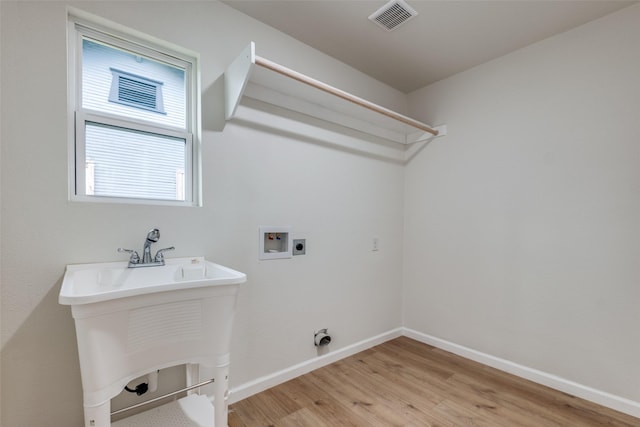 laundry area featuring electric dryer hookup, light hardwood / wood-style floors, sink, and hookup for a washing machine