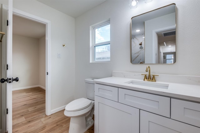 bathroom with hardwood / wood-style flooring, vanity, and toilet