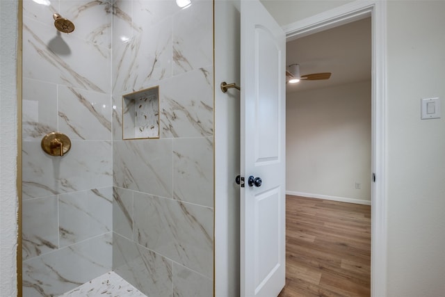 bathroom featuring a tile shower, ceiling fan, and wood-type flooring