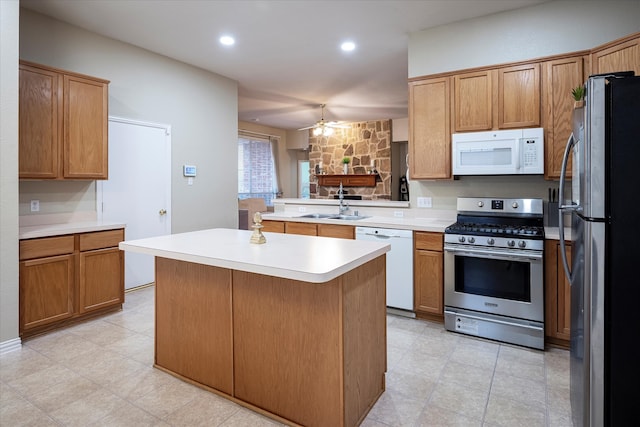 kitchen with sink, a center island, stainless steel appliances, and ceiling fan