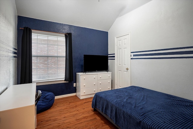 7906 Munich Dr, Rowlett, TX 75089 - bedroom featuring wood finished floors, a textured wall, vaulted ceiling, and baseboards